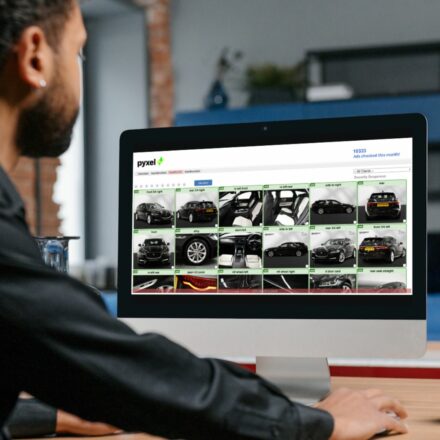 man reviewing the quality of car photographs submitted by a dealer